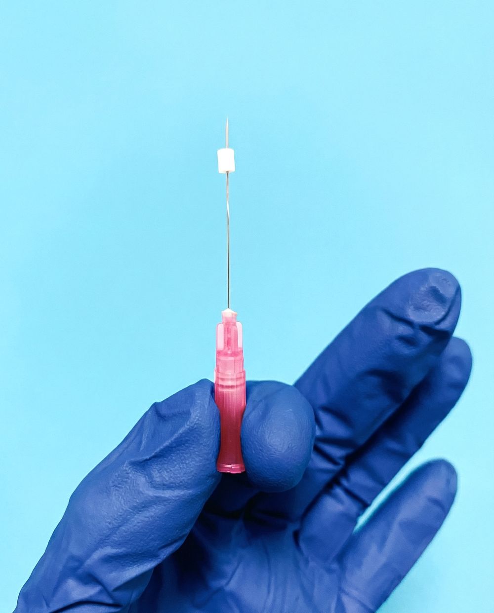 Preloaded needle held in gloved hand